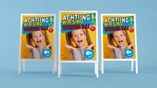 Mockup Schulstartplakataktion2025 Credit Deeplab Adobestock Edit Lwptm drei A-Ständer mit Plakaten, die ein Schulmädchen zeigen. Über dem Kopf ist der Schriftzug Achtung - Wir sind wieder da!