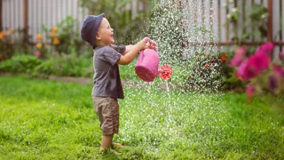 Adobestock 306104321 Bub Spielt Mit Giesskanne Im Garten C Natalialeb 2 Kleiner Bub spielt im Garten mit der Gießkanne