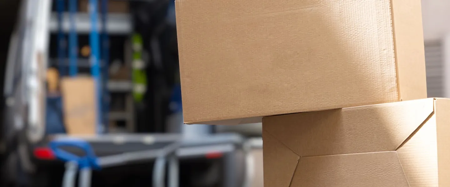 Ungesicherte Kartons liegen vor einem geöffneten Transporter am Boden