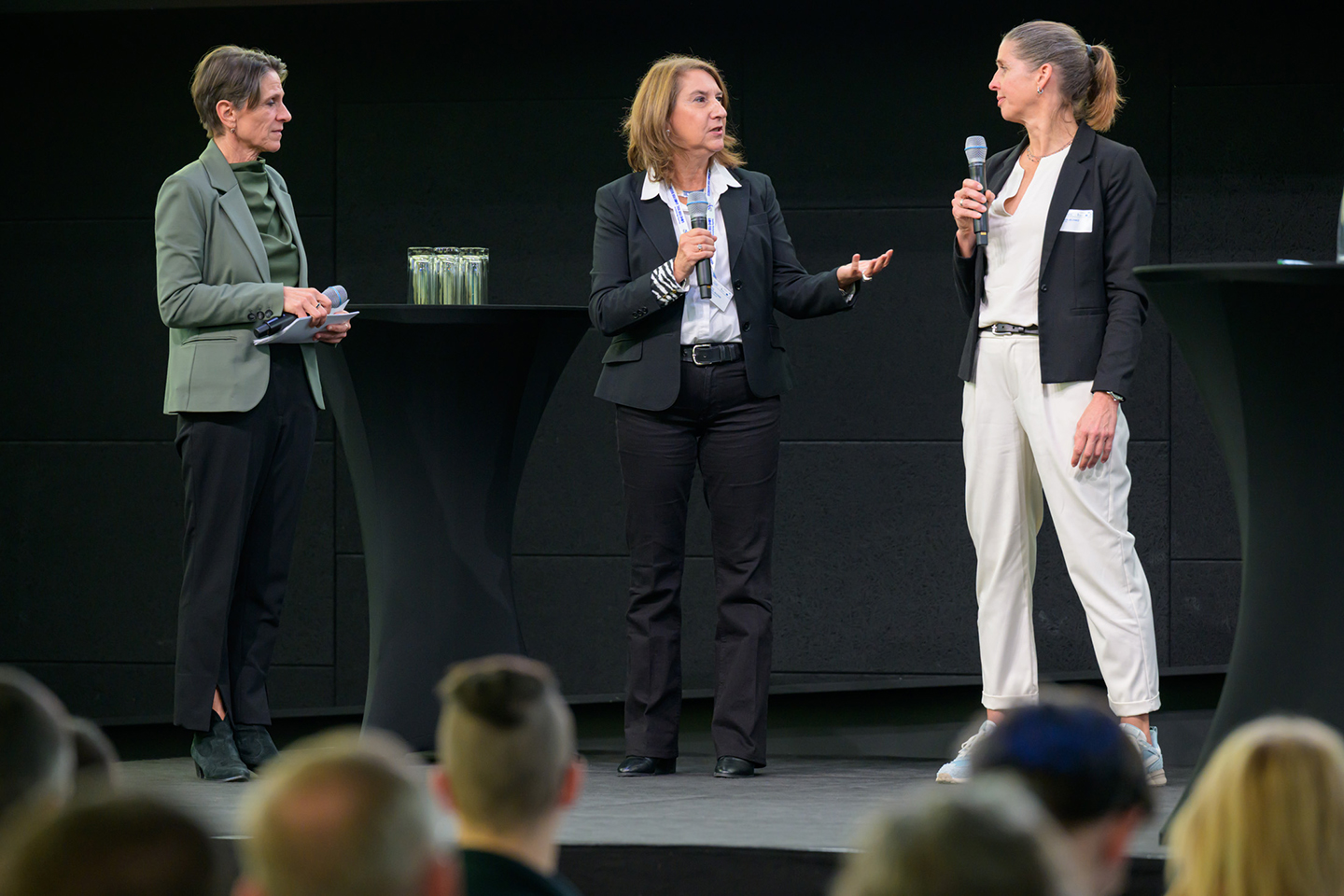 Drei Personen im Gespräch auf einer Bühne