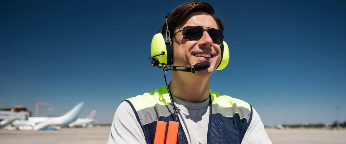 Adobestock 217902259 1440 ©Yakobchuk Olena Stock.Adobe.Com Mann mit Sonnenbrille und Headset schaut am Flughafen in die Sonne